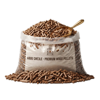 A clear plastic bag filled with brown wood pellets, with a gold scoop resting in the pile. The front label reads 'ABOU CHE3LE - PREMIUM WOOD PELLETS' with a small logo.