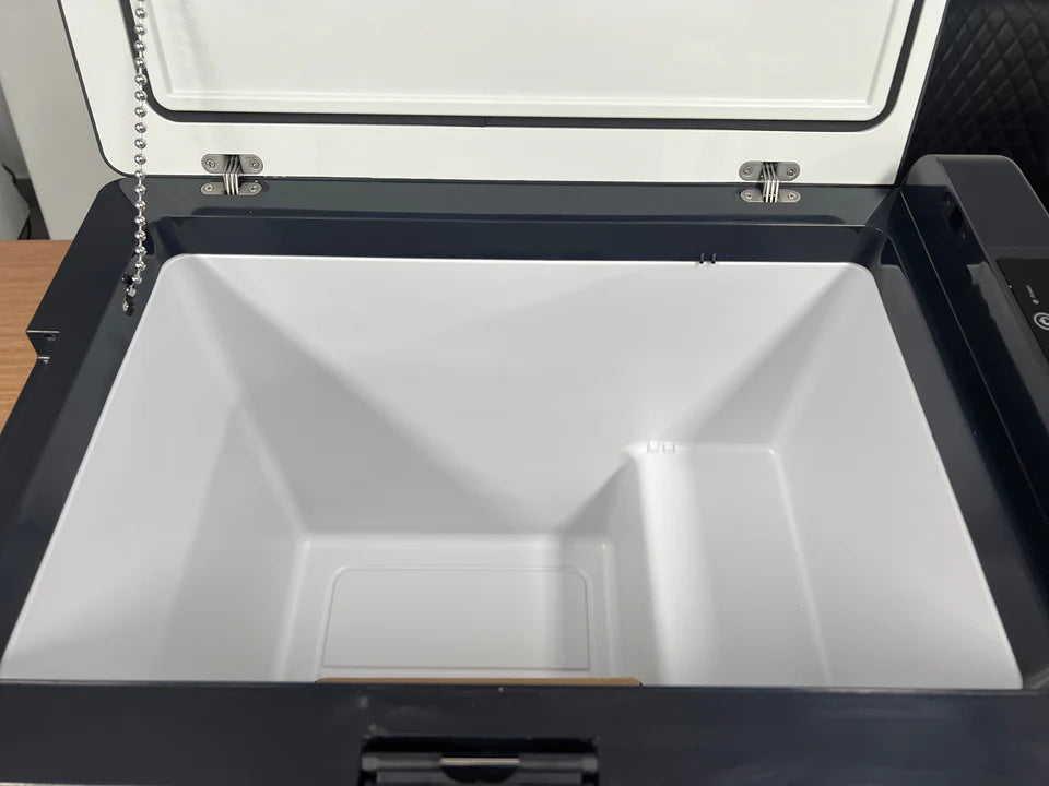An open white and black cooler or storage compartment with a clean interior, photographed from above.