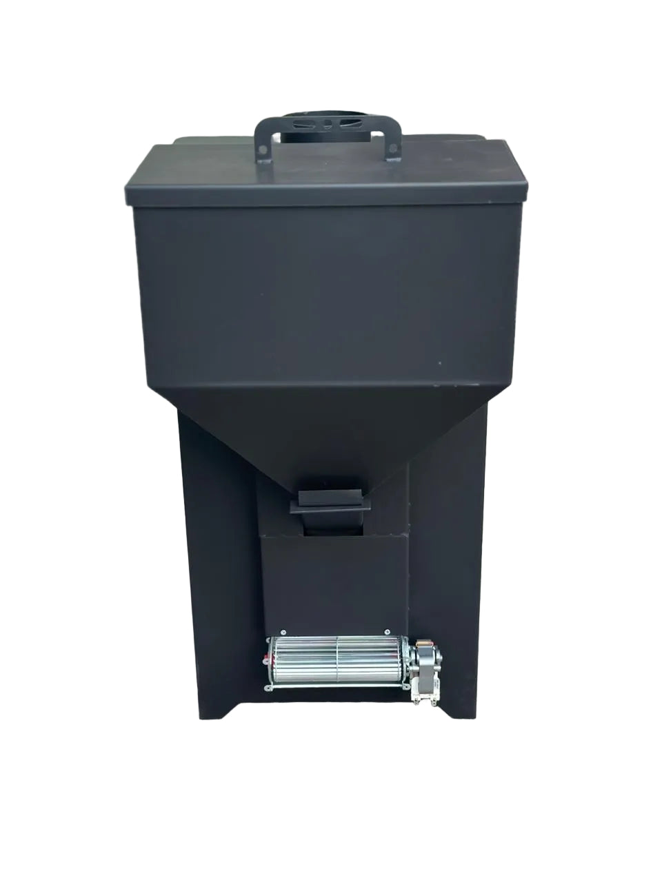 A black electric fuel grinder or grinder machine with a hopper on top, standing on a concrete floor in front of a building entrance.