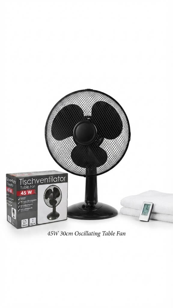 A 45W black oscillating table fan shown with its retail box, folded white towels, and a small remote control on a plain white background.