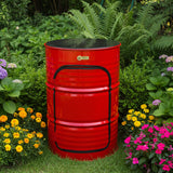 A bright red metal barrel-style side table or stool with a black top and black trim, photographed outdoors on a tiled floor next to another black barrel-shaped piece of furniture.